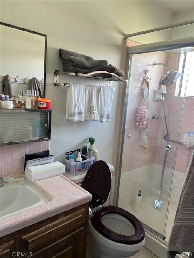 bathroom featuring vanity, backsplash, toilet, and walk in shower