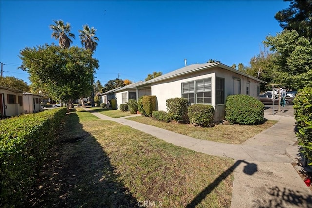 view of side of home with a yard