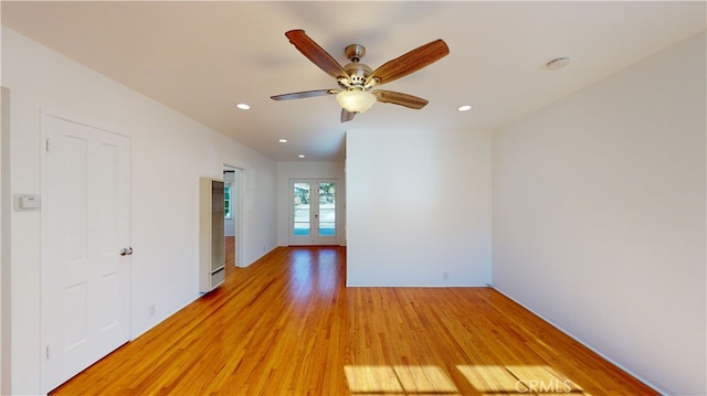 unfurnished room with ceiling fan, light wood-type flooring, and french doors