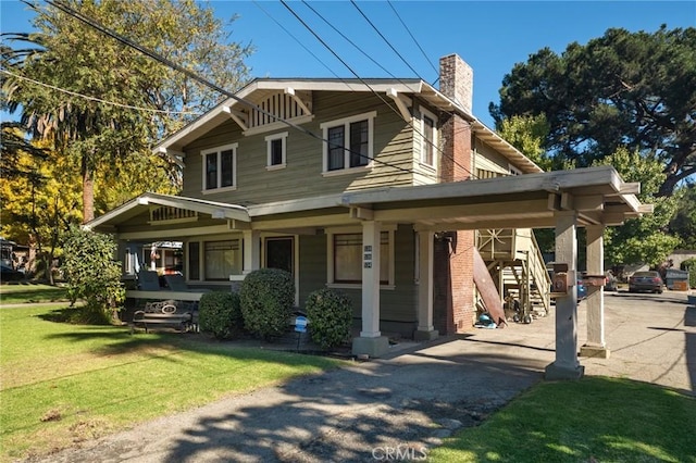 view of front facade with a front lawn, a carport, and a porch