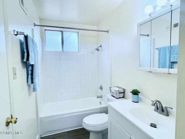 full bathroom featuring tiled shower / bath combo, vanity, hardwood / wood-style floors, and toilet