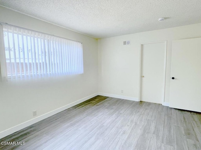 unfurnished bedroom featuring a textured ceiling and light wood-type flooring