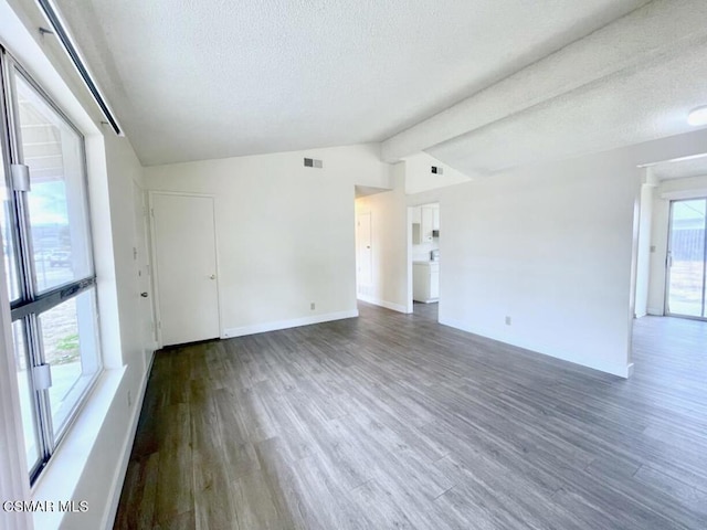 empty room with dark hardwood / wood-style flooring, vaulted ceiling with beams, and a healthy amount of sunlight