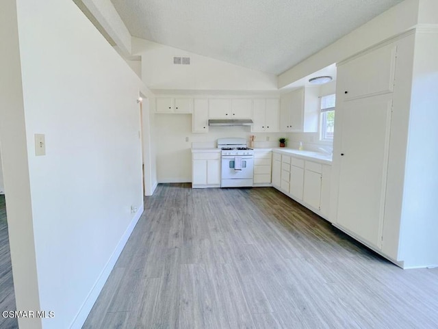 kitchen with white cabinetry, vaulted ceiling, white gas stove, and light wood-type flooring