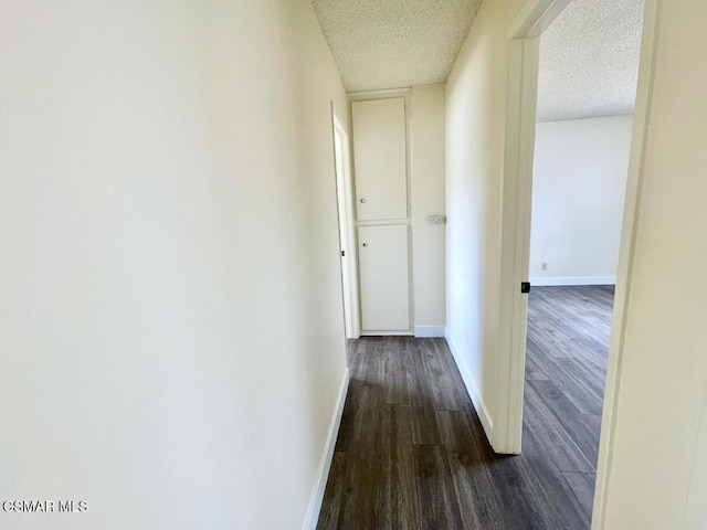 hallway featuring dark hardwood / wood-style floors and a textured ceiling