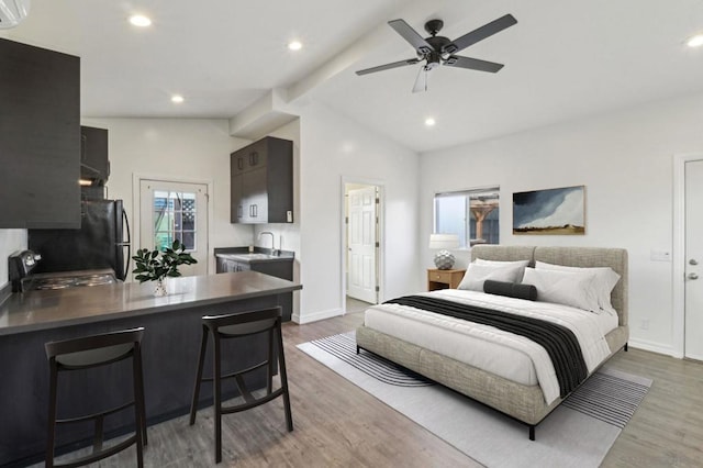 bedroom featuring black fridge, dark wood-type flooring, vaulted ceiling with beams, and sink