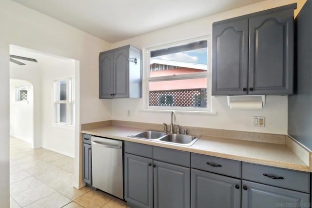 kitchen with light tile patterned floors, dishwasher, sink, and gray cabinetry