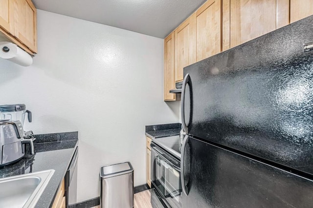 kitchen featuring extractor fan, black appliances, sink, and light brown cabinets