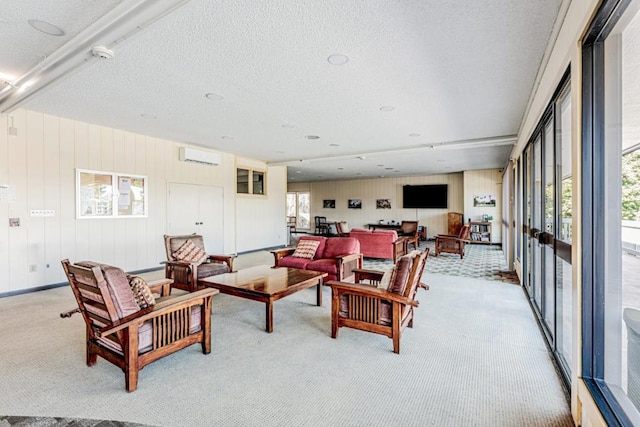 living room featuring light carpet, a textured ceiling, and a wall unit AC