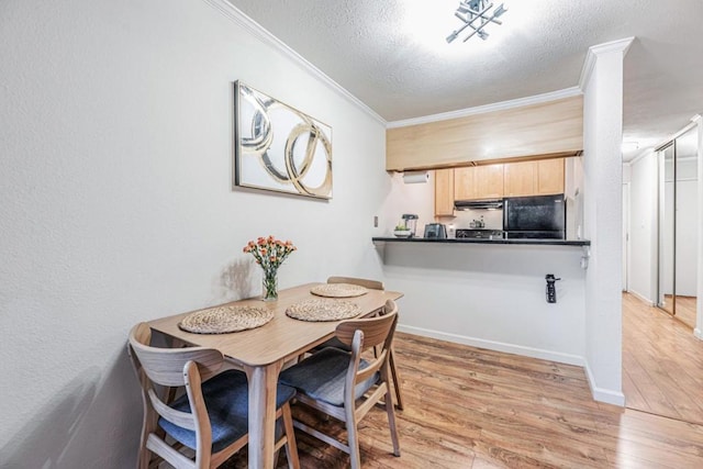 dining area featuring crown molding, light hardwood / wood-style flooring, and a textured ceiling