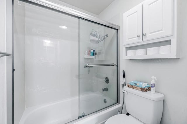 bathroom featuring shower / bath combination with glass door and toilet