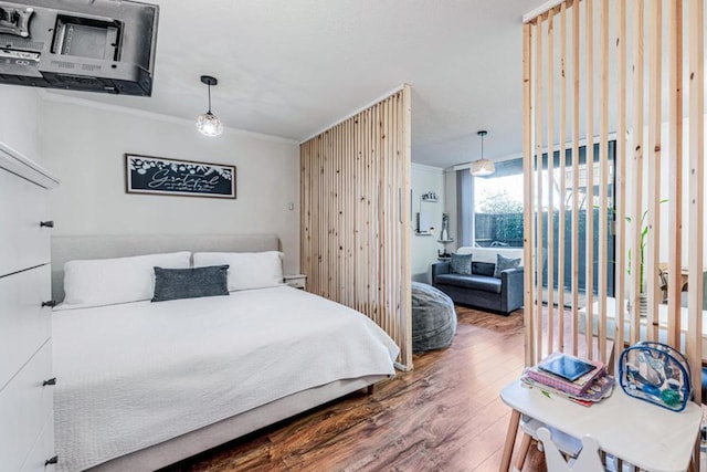 bedroom with crown molding and hardwood / wood-style flooring