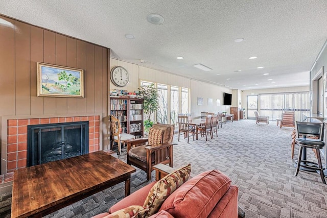 carpeted living room featuring a textured ceiling and wood walls