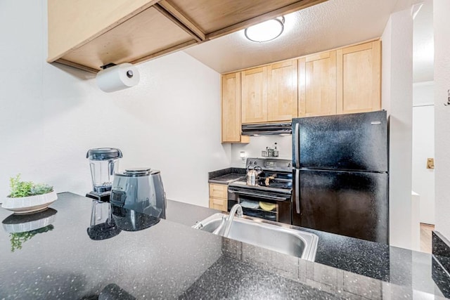 kitchen featuring dark stone countertops, light brown cabinetry, sink, and black appliances