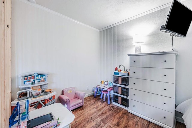 playroom with hardwood / wood-style flooring and ornamental molding