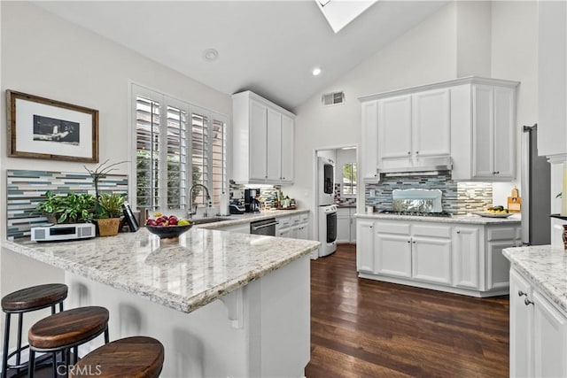 26800 Monet Ln, Valencia, CA 91355 - kitchen with visible vents, light stone counters, white cabinetry, and under cabinet range hood