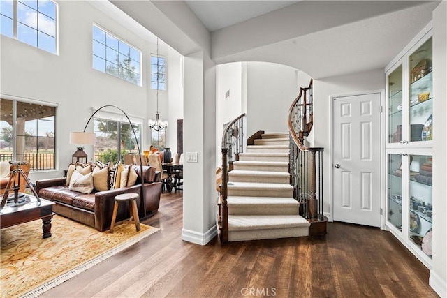 26800 Monet Ln, Valencia, CA 91355 - stairs with a towering ceiling, an inviting chandelier, arched walkways, and wood finished floors