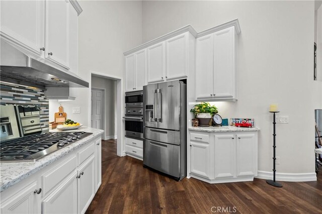26800 Monet Ln, Valencia, CA 91355 - kitchen featuring dark wood-style floors, under cabinet range hood, white cabinetry, and stainless steel appliances