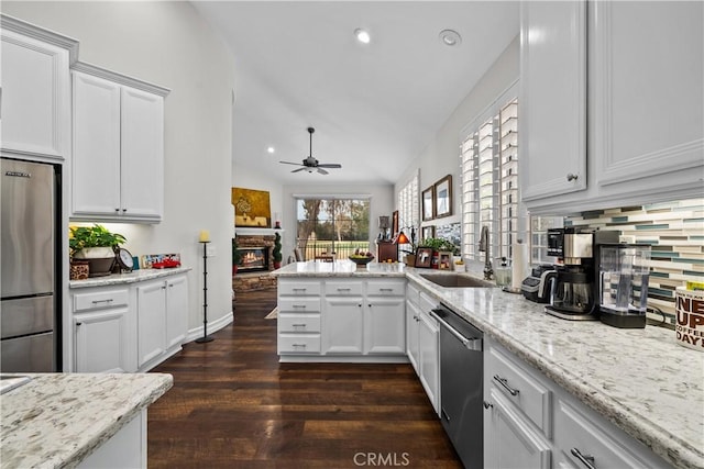 26800 Monet Ln, Valencia, CA 91355 - kitchen with appliances with stainless steel finishes, white cabinetry, a sink, and a stone fireplace