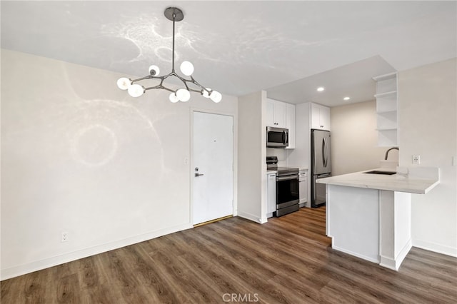 kitchen featuring white cabinetry, hanging light fixtures, stainless steel appliances, dark hardwood / wood-style flooring, and kitchen peninsula