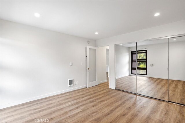 unfurnished bedroom with light hardwood / wood-style floors and a closet