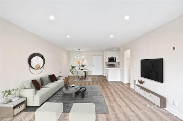 living room with a chandelier and light hardwood / wood-style flooring