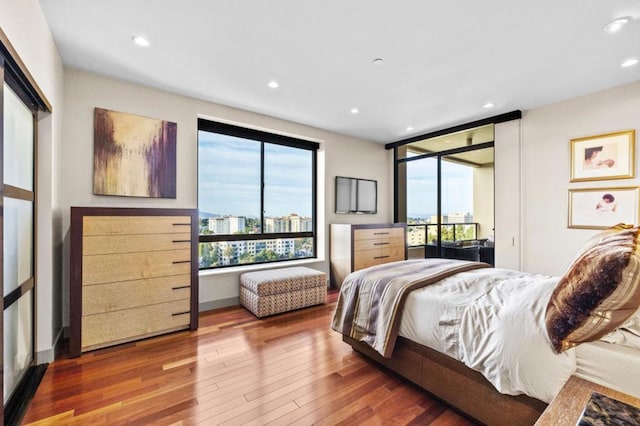 bedroom with hardwood / wood-style floors and access to exterior