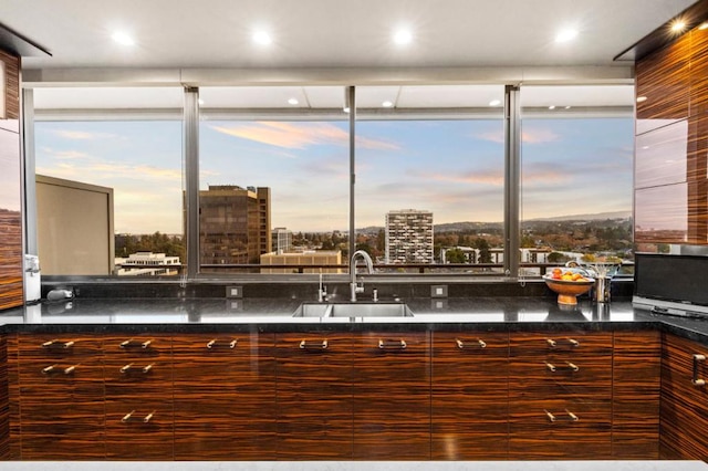 kitchen with dark stone counters, sink, and a wealth of natural light