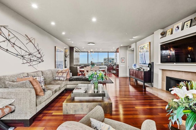 living room with floor to ceiling windows, dark hardwood / wood-style floors, and a tiled fireplace