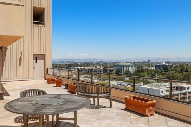 balcony featuring a mountain view and a patio area