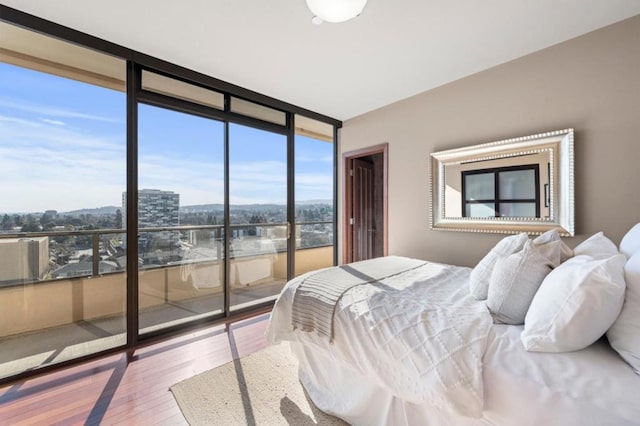 bedroom featuring a wall of windows and light wood-type flooring