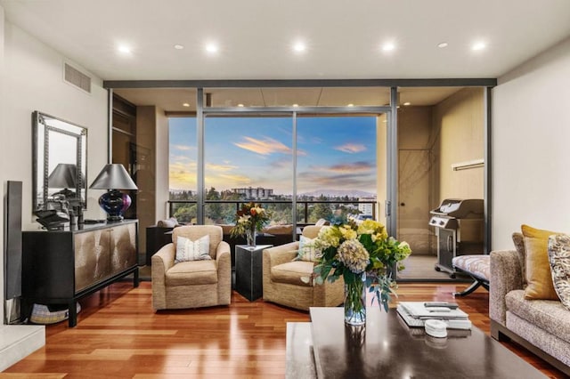 living room with a wall of windows and light hardwood / wood-style flooring