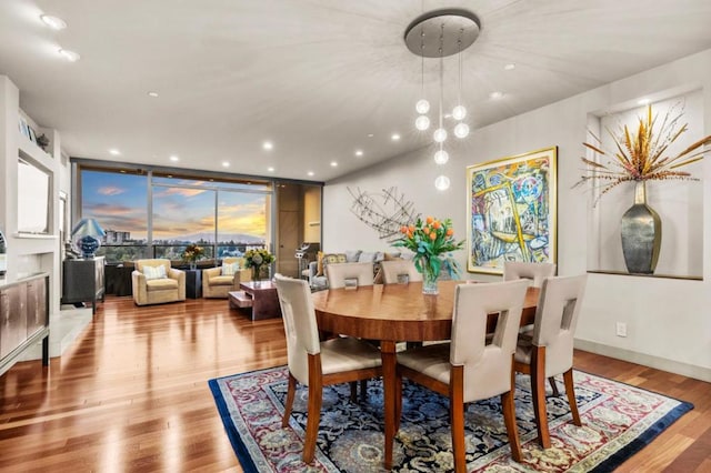 dining area featuring expansive windows and light hardwood / wood-style flooring