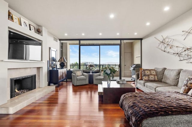 living room with floor to ceiling windows, dark hardwood / wood-style floors, and a fireplace