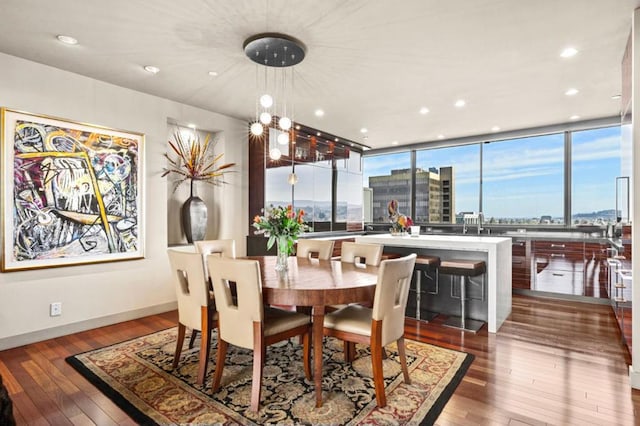 dining room with a wall of windows, a chandelier, and hardwood / wood-style floors