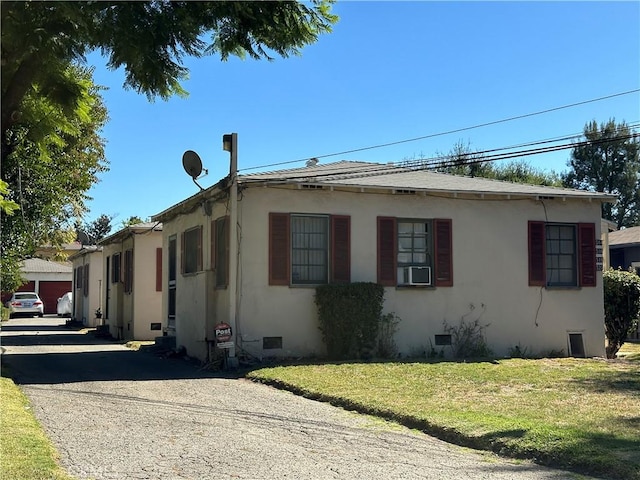 view of side of property featuring cooling unit and a yard