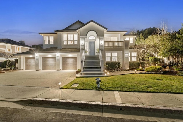 view of front of property with a garage, a balcony, and a lawn