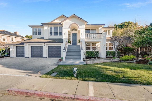 view of front of home featuring a garage, a balcony, and a front yard