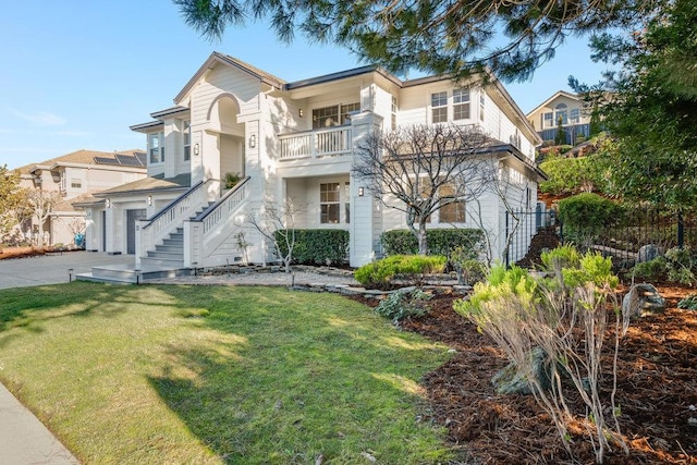 view of front of property featuring a garage, a front yard, and a balcony