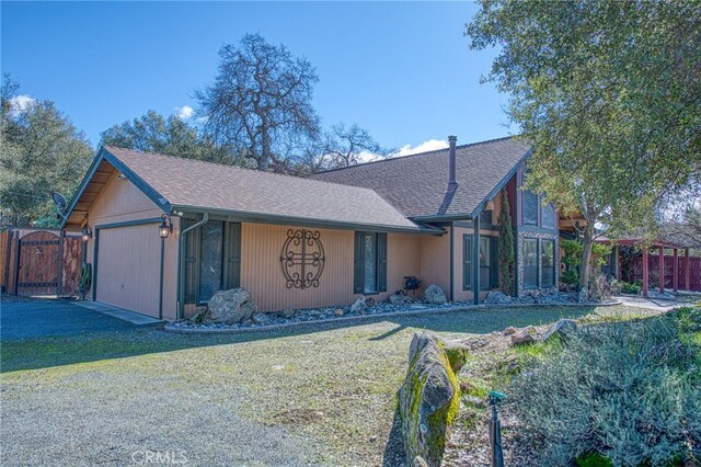 ranch-style house featuring a garage and a front yard