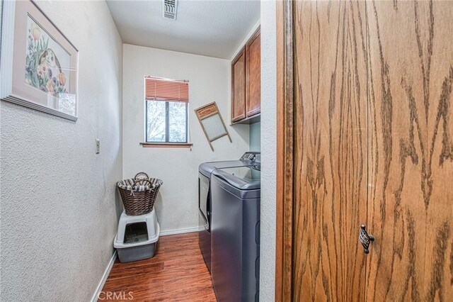 washroom featuring cabinets, washer and dryer, and dark hardwood / wood-style flooring