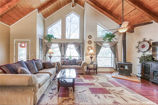 living room with hardwood / wood-style flooring, high vaulted ceiling, wooden ceiling, beamed ceiling, and a wood stove