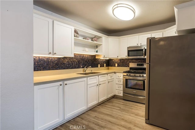 kitchen featuring sink, light hardwood / wood-style flooring, stainless steel appliances, and white cabinets