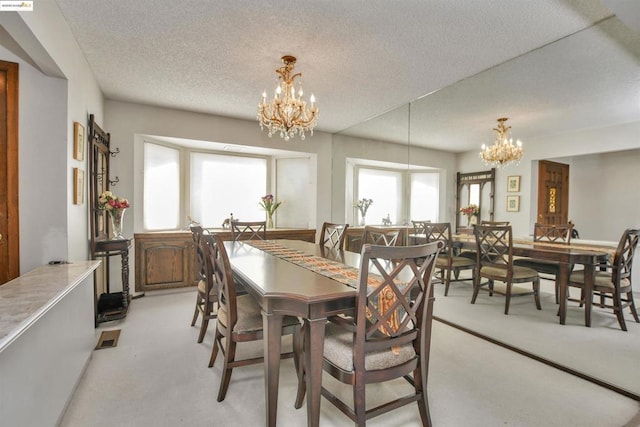 carpeted dining area featuring a textured ceiling and a chandelier