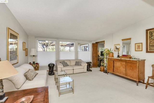 living room featuring lofted ceiling and light carpet