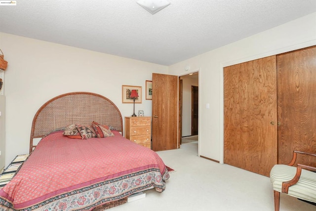 bedroom featuring a closet, light carpet, and a textured ceiling