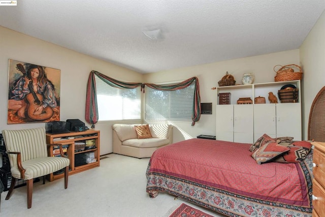 bedroom featuring light carpet and a textured ceiling