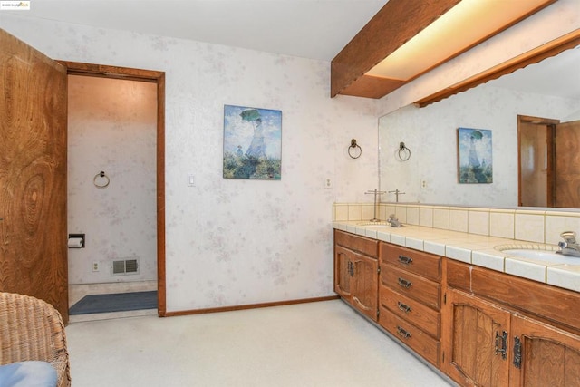 bathroom with vanity and beam ceiling