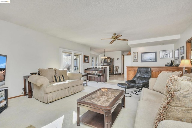 carpeted living room featuring lofted ceiling, ceiling fan with notable chandelier, and a textured ceiling