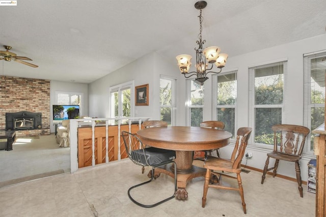 dining room with ceiling fan with notable chandelier and a textured ceiling